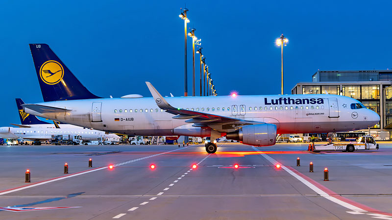 Foto eines Lufthansa-Flugzeuges auf dem Vorfeld des Flughafen-BER am Abend