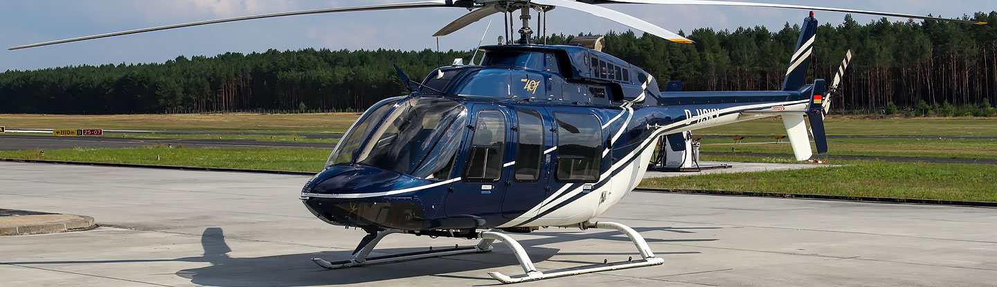 ein auf einem Flugplatz abgestellter blauweißer Hubschrauber