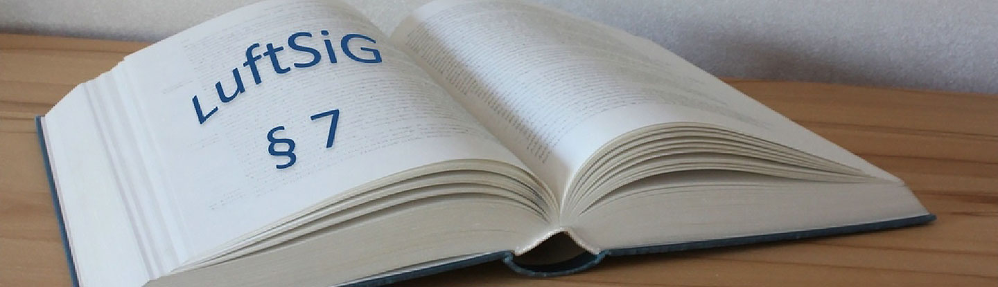aufgeschlagenes Buch auf einem Tisch mit blauen Buchstaben LuftSig § 7